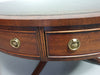 Mahogany Victorian " Heldense " Coffee table / Drum table with leather top on brass wheels. '80s