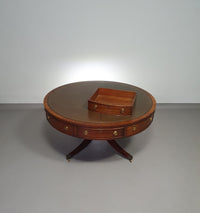 Mahogany Victorian " Heldense " Coffee table / Drum table with leather top on brass wheels. '80s