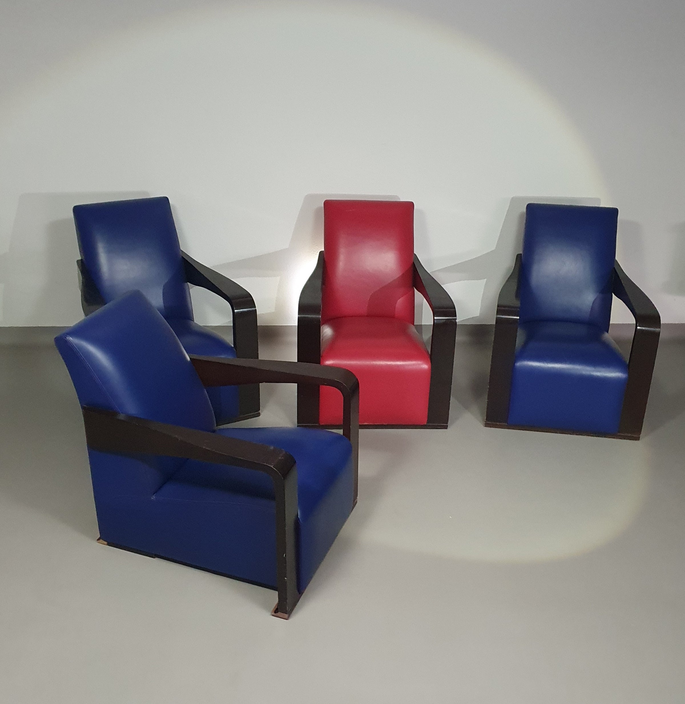 4 x Vintage Ying lounge chairs / fauteuils van Hugues Chevalier, jaren 1990. 3 x blue / 1 x red leather. Special made in these colours for Tommy Hilfiger. With traces of use.