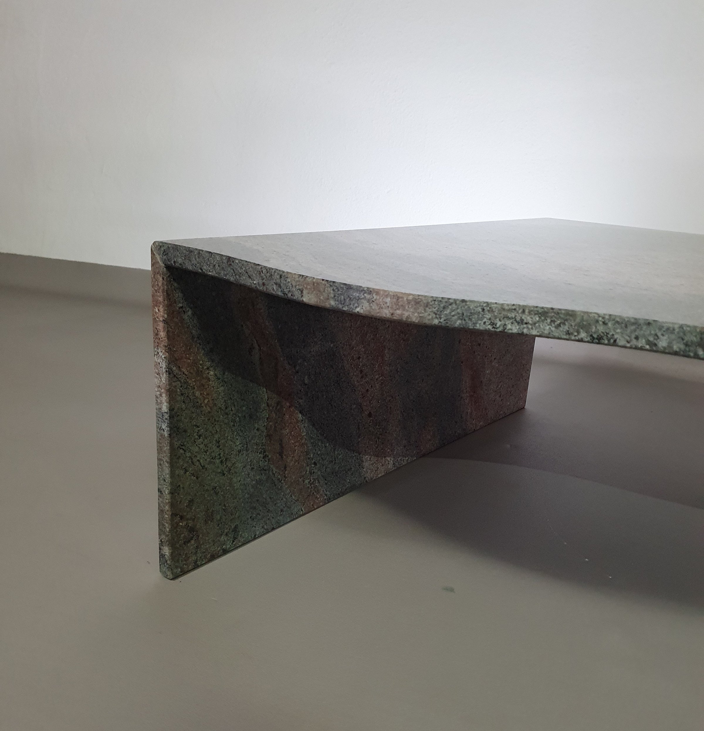 A free form large granite coffee table with three straight lines contrasting to a wavy front. 1970s