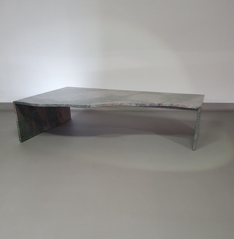 A free form large granite coffee table with three straight lines contrasting to a wavy front. 1970s